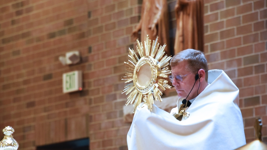 t. Mary pastor Father Kevin Huber raises the monstrance as he leads benediction in June 2023.